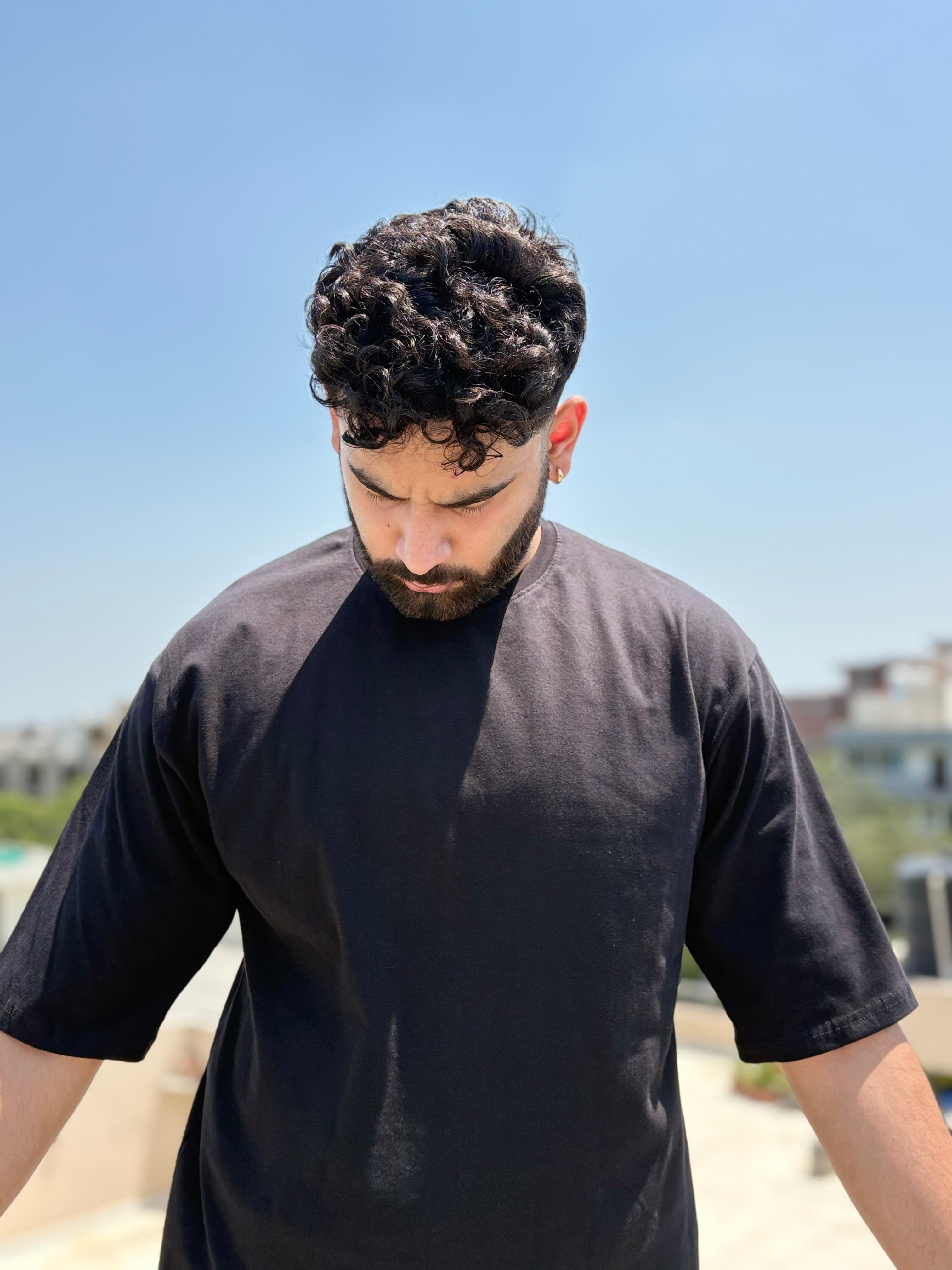 Person wearing The Artist Within oversized graphic T-shirt in black